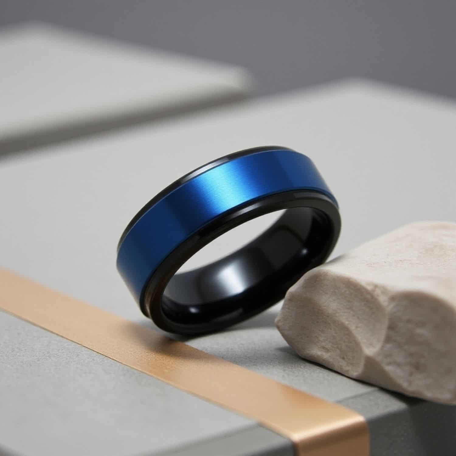Side angle close-up of black tungsten ring with blue centre highlighting polished edges