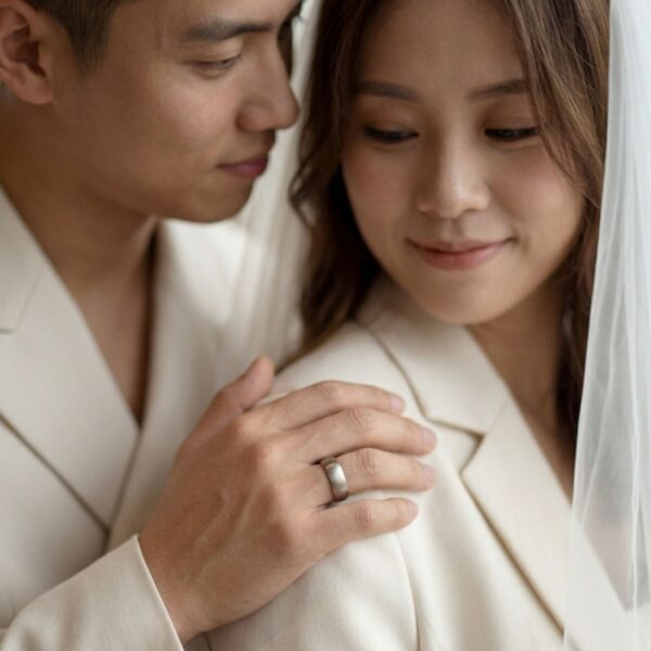 Groom wearing a brushed silver titanium wedding ring with black interior, shown on hand during wedding ceremony