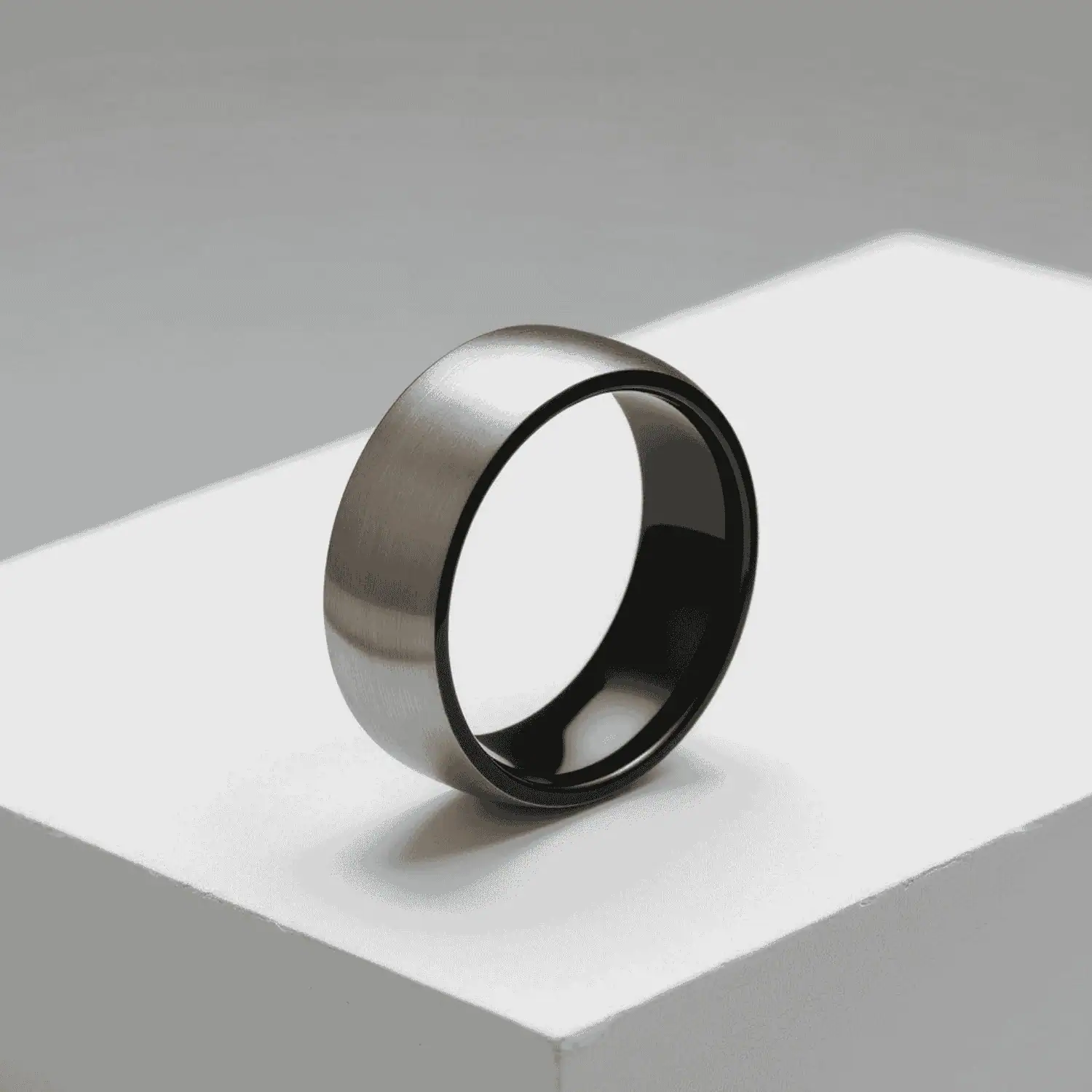 Mans engagement ring. A brushed silver titanium ring for gents featuring black rims and a black interior.