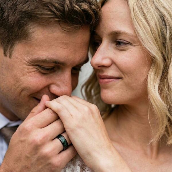 At the wedding, the newly wed couple hold hands, the man showing his green and black ring, made with carbon and tungsten.