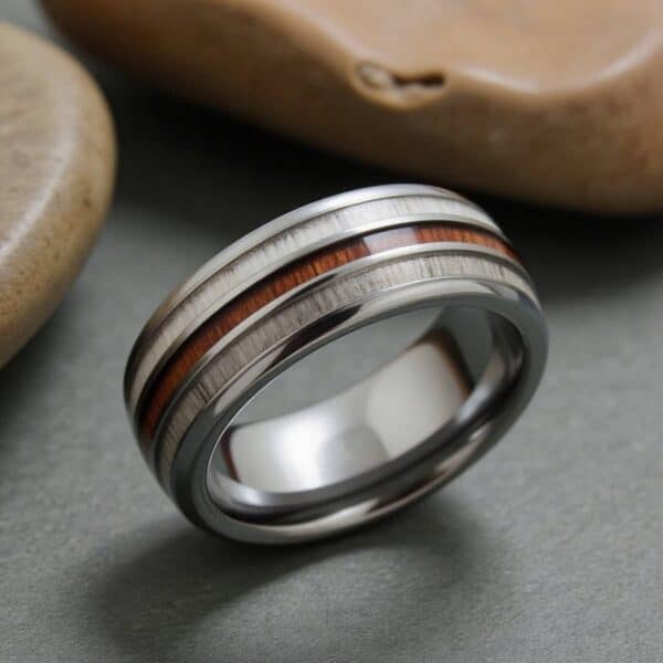 Men’s tungsten ring with wood and antler detailing, worn as a fashion statement ring.