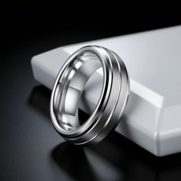 Polished silver men’s tungsten fashion ring with raised detailing, worn as a statement ring for him.