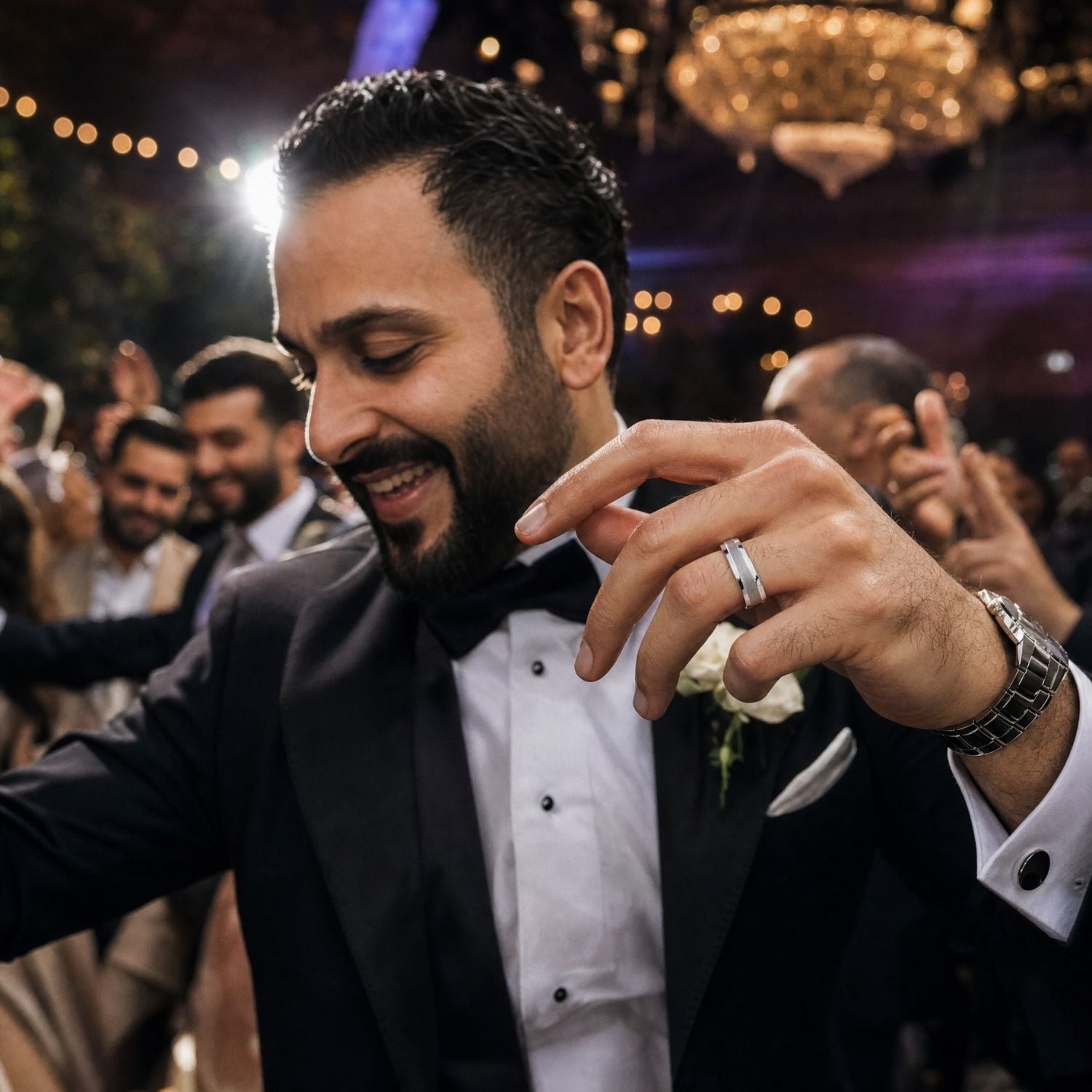 Groom dancing with guests at his wedding while wearing The Knight silver tungsten wedding band with a brushed centre and polished sides.