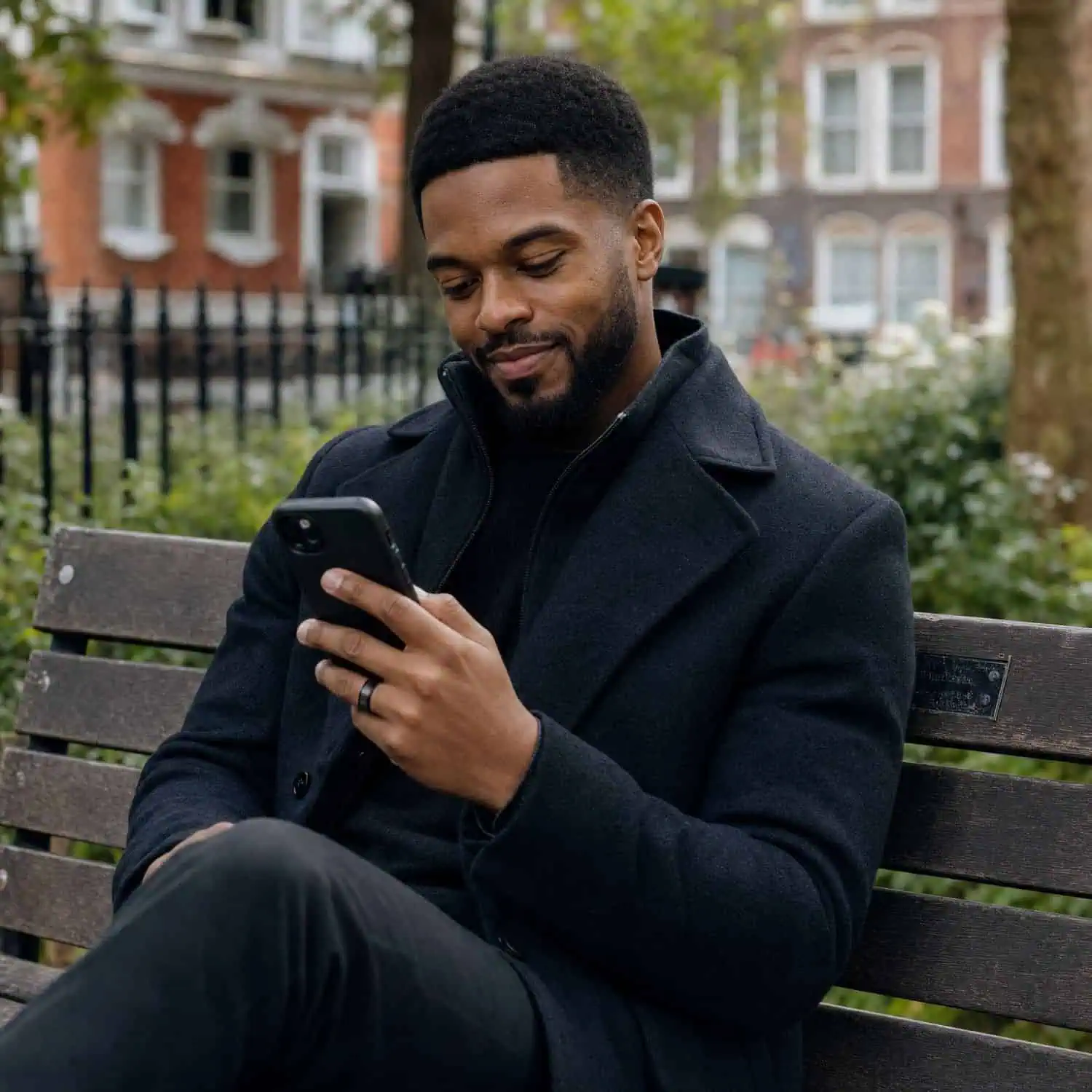Relaxed man sitting on a park bench while wearing the Spirit black tungsten carbide ring with a brushed finish and polished edges.