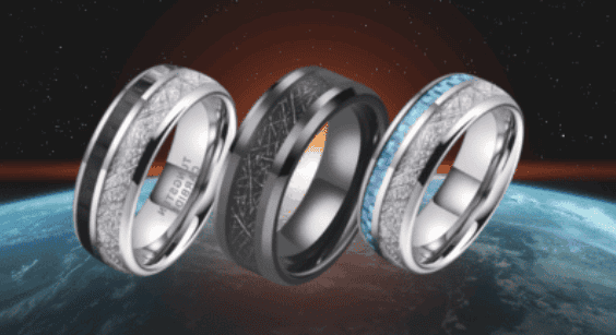 Three futuristic men’s rings displayed above Earth with a cosmic background featuring black, silver, and blue inlays with meteorite-style textures and polished metal finishes.
