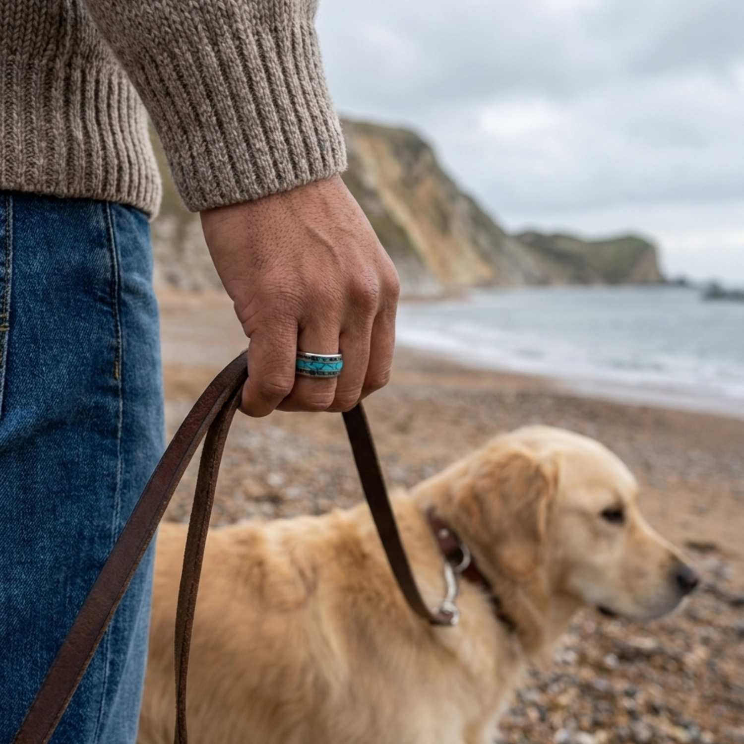 Man walking his golden retriever along the beach while wearing the Rio silver tungsten ring with turquoise and natural abalone shell inlays.