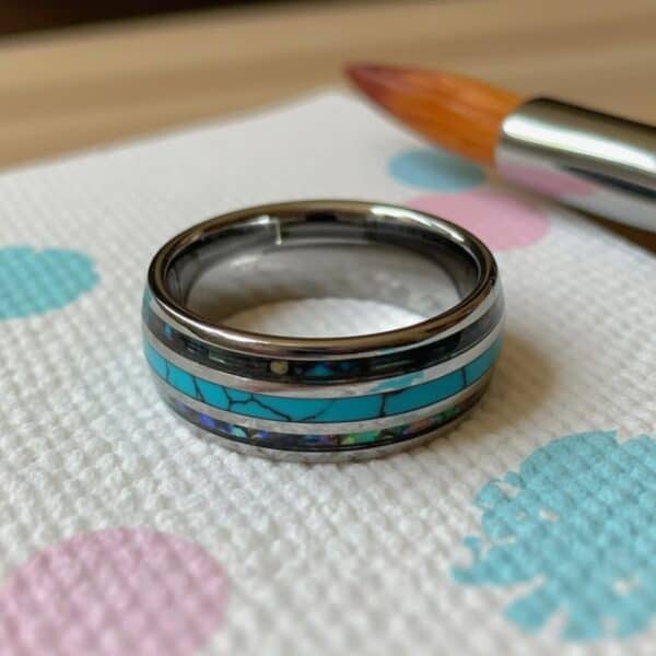 The Rio men’s tungsten wedding ring featuring turquoise centre and abalone shell sides with engraving.