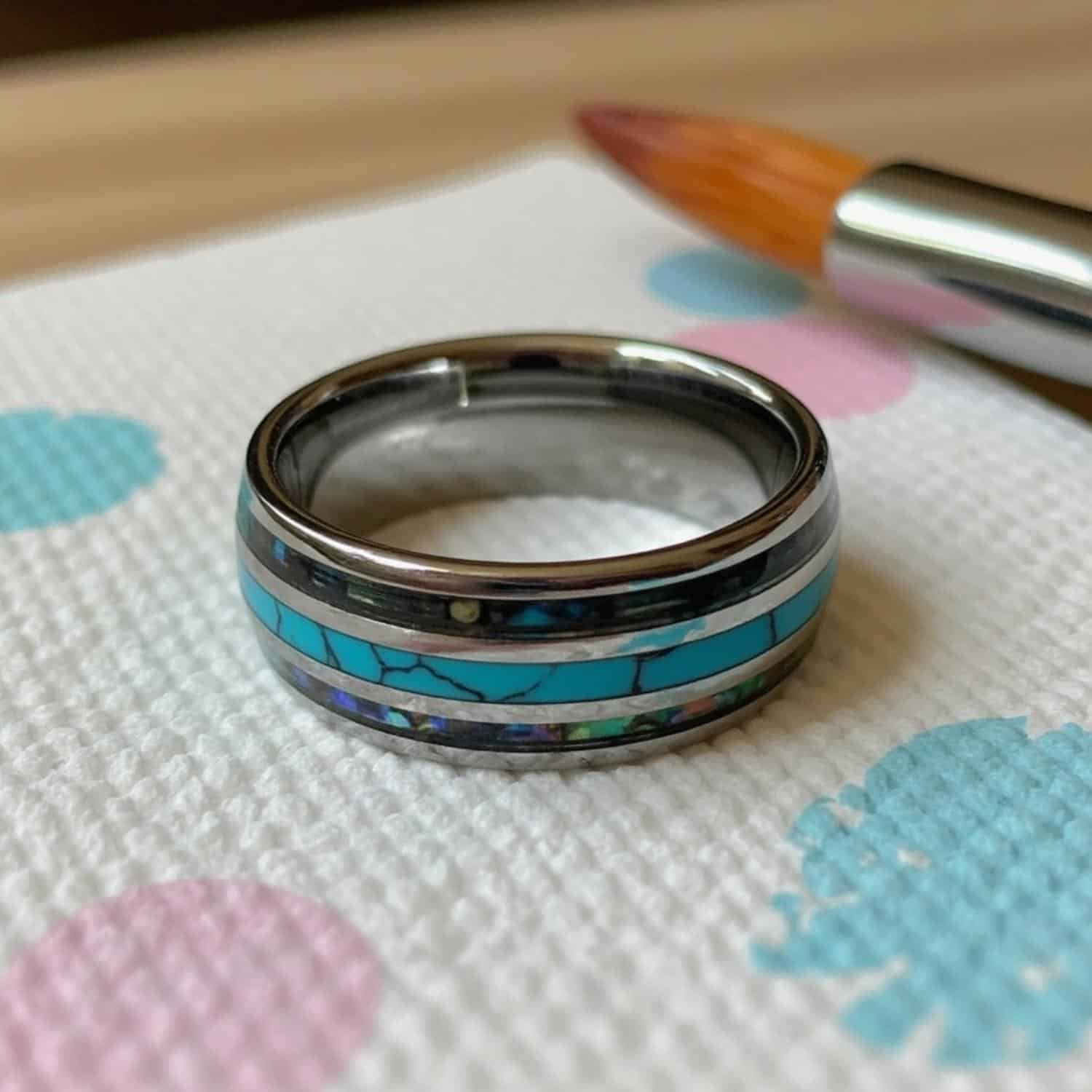 The Rio men’s tungsten wedding ring featuring turquoise centre and abalone shell sides with engraving.