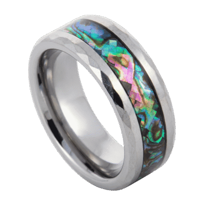 Close-up of the Reef silver tungsten carbide ring featuring a shimmering abalone shell inlay and multi-faceted bevelled edges against a clean background.