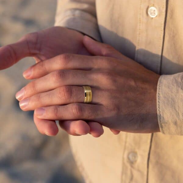 Man wears gold tungsten wedding band