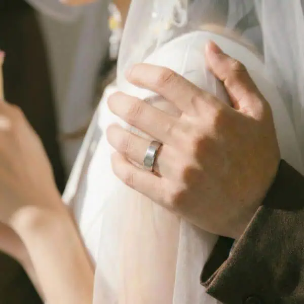 The newly wed couple pose for a photo, the man wearing a white gold tungsten ring.