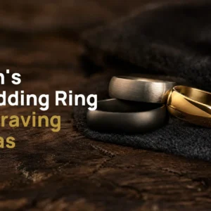 Three men's wedding bands in black, brushed silver-coloured and gold-coloured finishes on dark wood, with the title Men's Wedding Ring Engraving Ideas