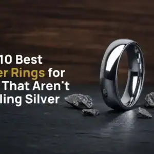 The Elie polished silver-coloured tungsten ring standing on dark slate beside flecks of raw tungsten, with the title The 10 Best Silver Rings for Men That Aren't Sterling Silver