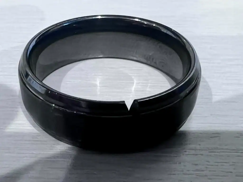 A coated black tungsten ring with a chipped edge after a knock against a hard surface