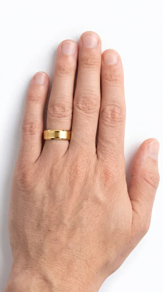 The Guardian brushed gold-coloured tungsten ring with polished edges worn on the ring finger of a man's hand