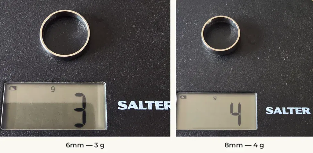 The Resolve 6mm and 8mm silver-coloured titanium rings on a Salter scale reading 3 g and 4 g