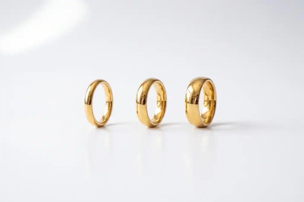 4mm, 6mm and 8mm gold tungsten rings standing side by side, showing ring width edge to edge