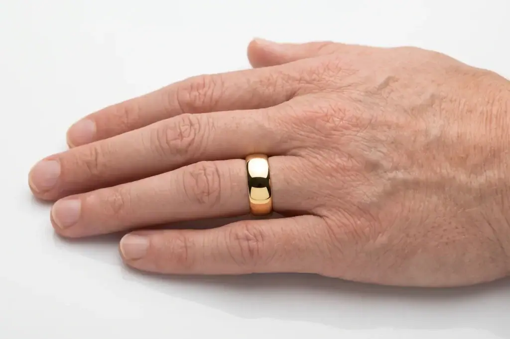 An 8mm gold tungsten ring (the King) worn on a man's ring finger